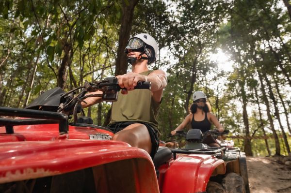 Couple riding an ATV through the jungle in Cancun